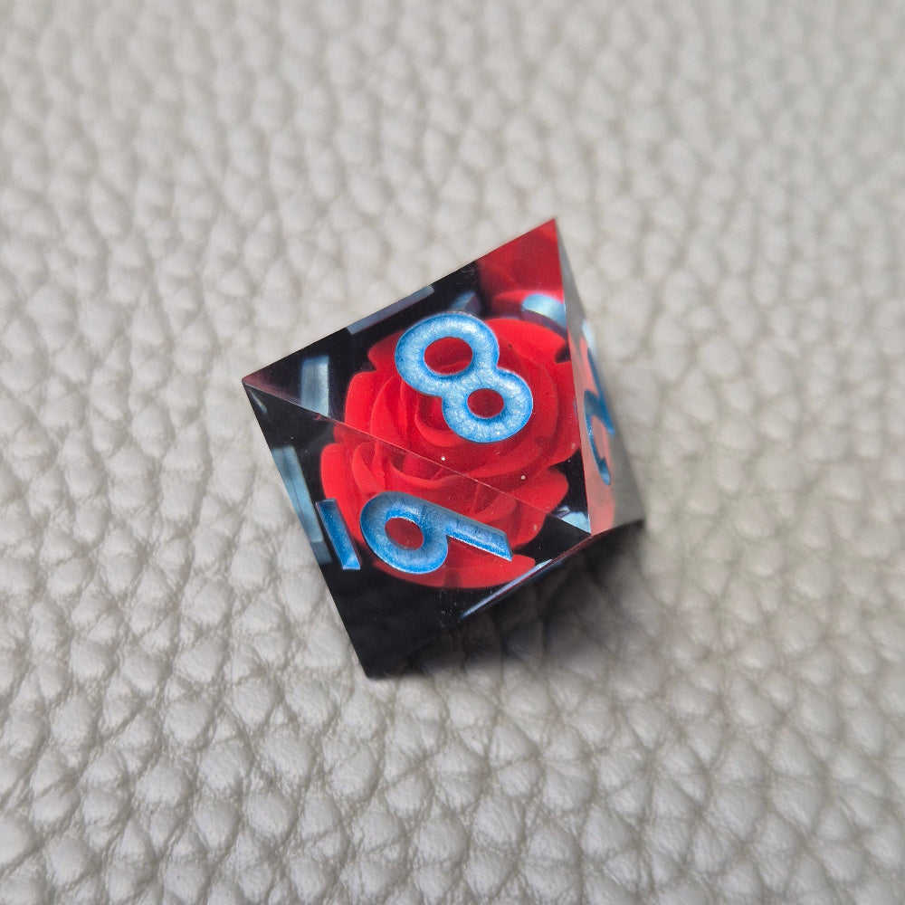 A set of clear sharp-edge resin dice with black ground color and red rose inside.