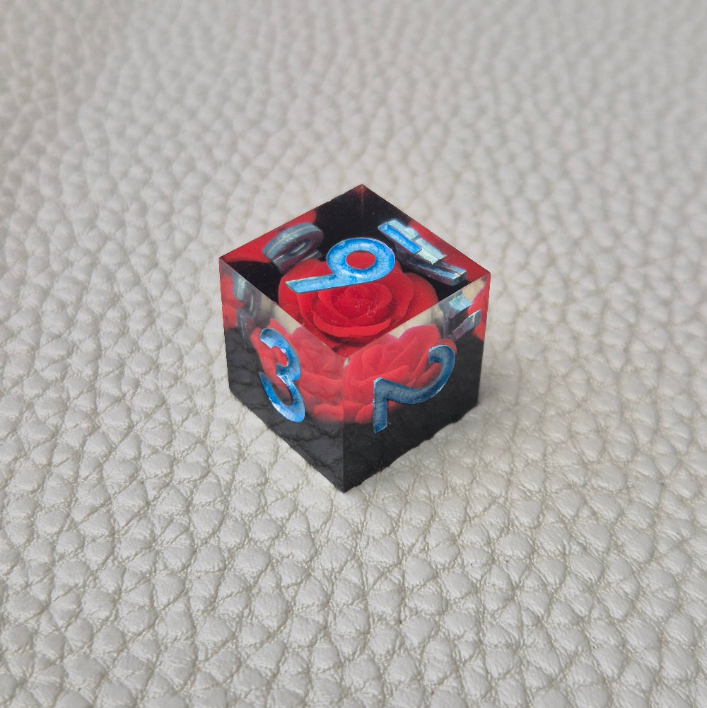 A set of clear sharp-edge resin dice with black ground color and red rose inside.