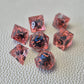 A set of red tinted clear liquid core dice with a moving dragon eye inside on a white textured background