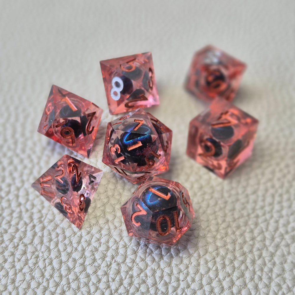 A set of red tinted clear liquid core dice with a moving dragon eye inside on a white textured background