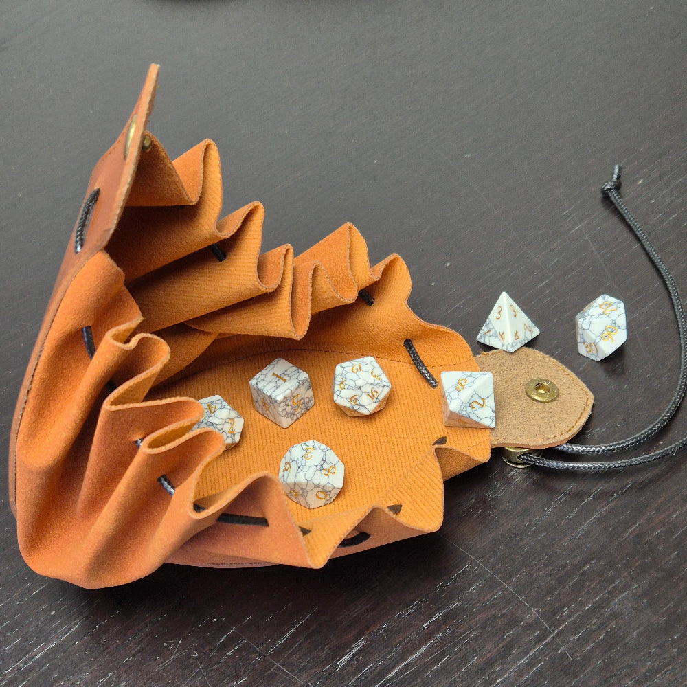 A brown leather dice bag with buttons and rope to tightly close it. Displayed on a black textured background