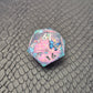 A set of light blue resin dice with pink liquid core and blue butterflies, displayed on black textured background