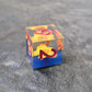 A set of clear sharp-edge resin dice with blue ground color and yellow flower inside on a black surface