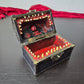 A brown ang gold mimic chest for dice storage With red and black painted mimic with teeth inside