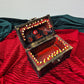 A brown ang gold mimic chest for dice storage With red and black painted mimic with teeth inside