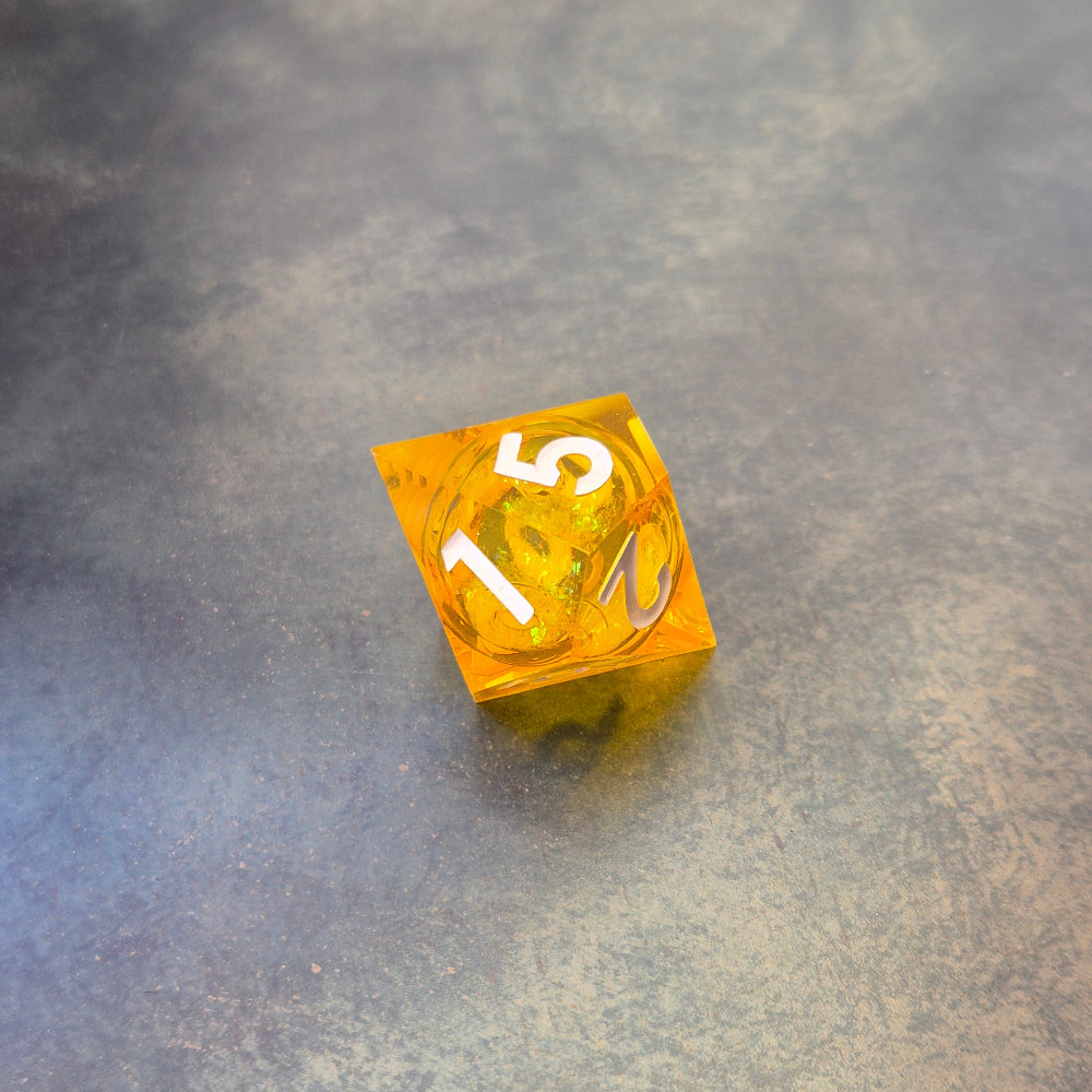 A set of rainbow coloured resin dice witch liquid core displayed on metal plate