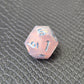A set of pink sharp edge resin dice with blue numbers on a black textured surface